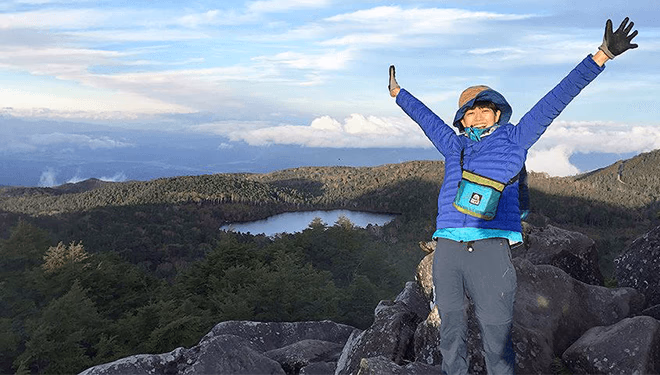 Fujiwara climbing a mountain with the Monosasu Mountaineering Club shortly after joining the company.