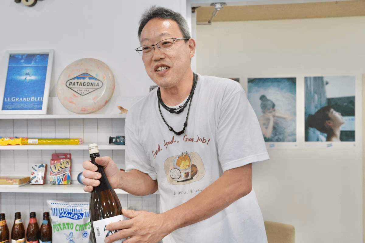 Iino-san holding a bottle of sake
