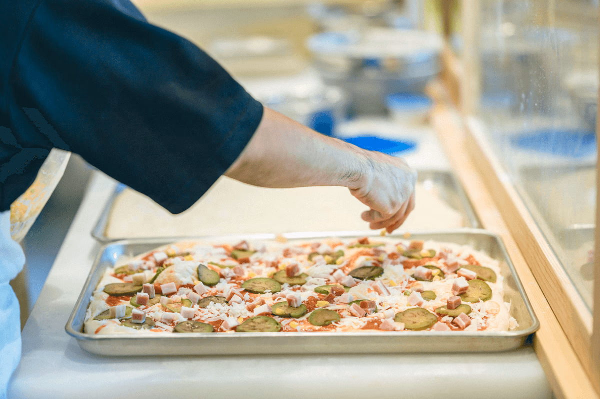 Topping pizza with cheese and vegetables