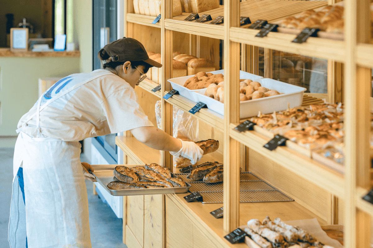 Bending over to put bread on display at the store
