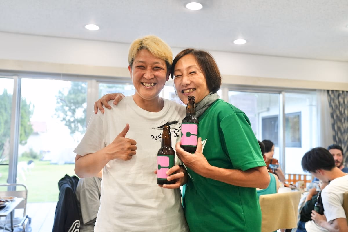 Two women smiling and holding beer