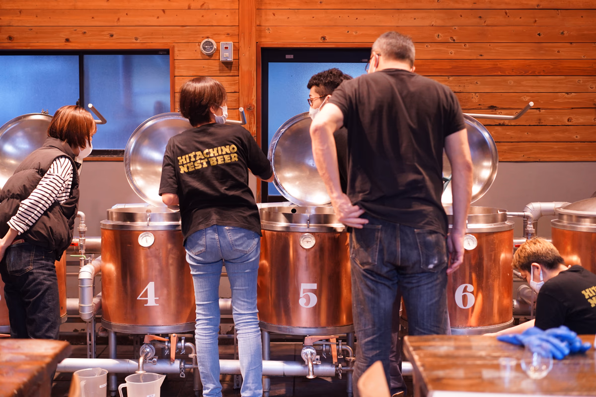 The four of them watch beer being brewed