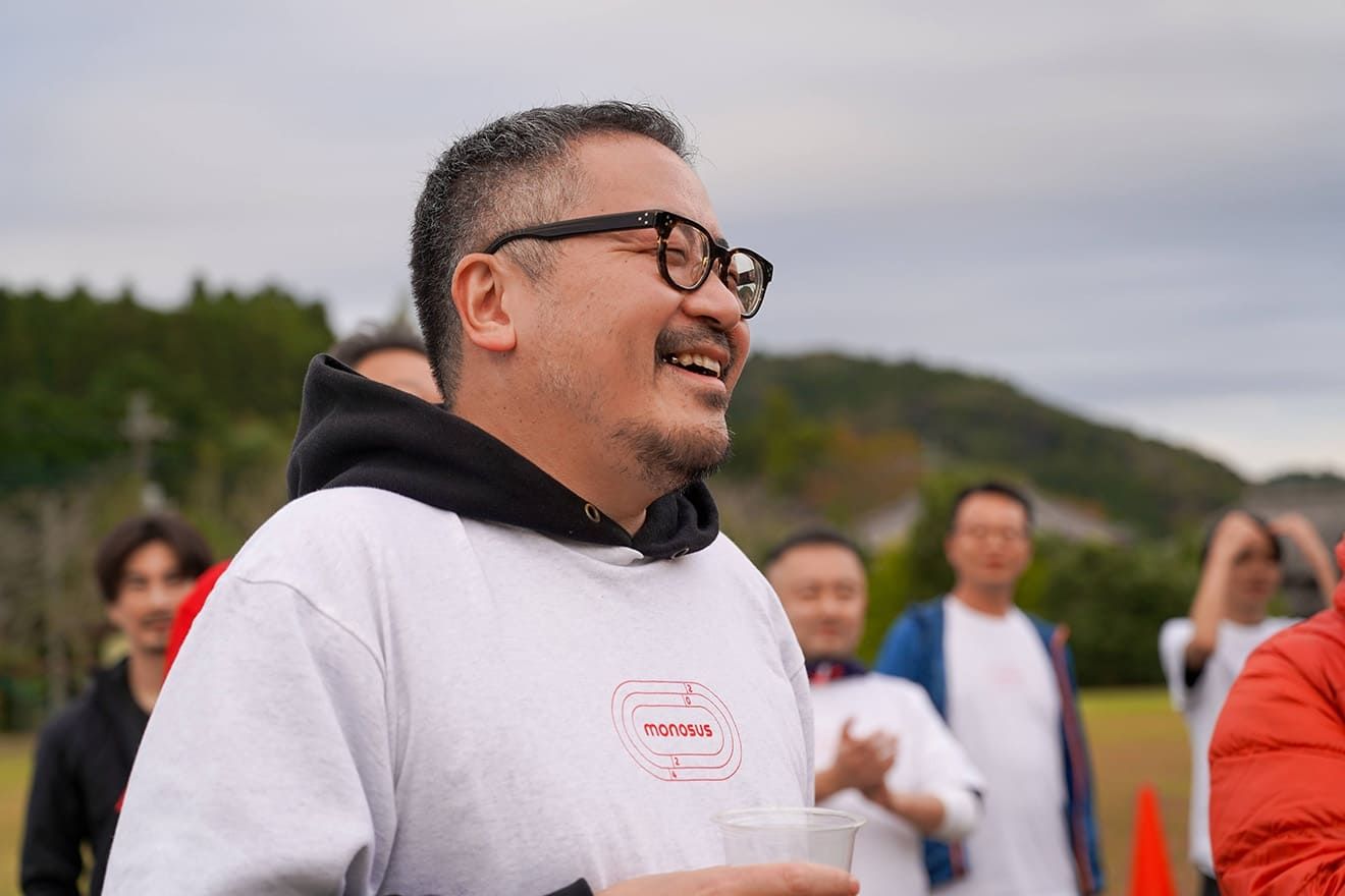 Man laughing while holding a beer