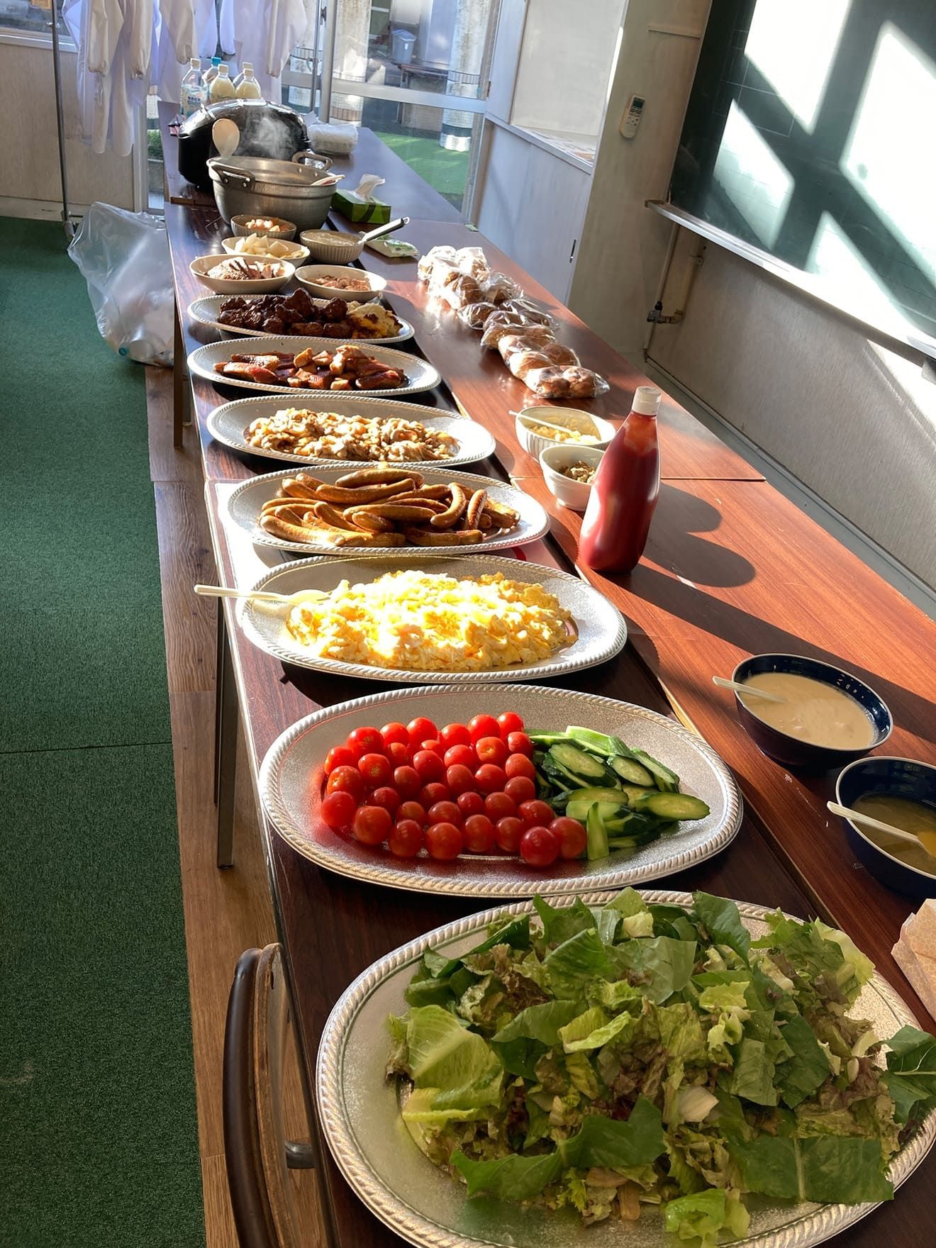 A breakfast menu including scrambled eggs, cherry tomatoes, and sausages.